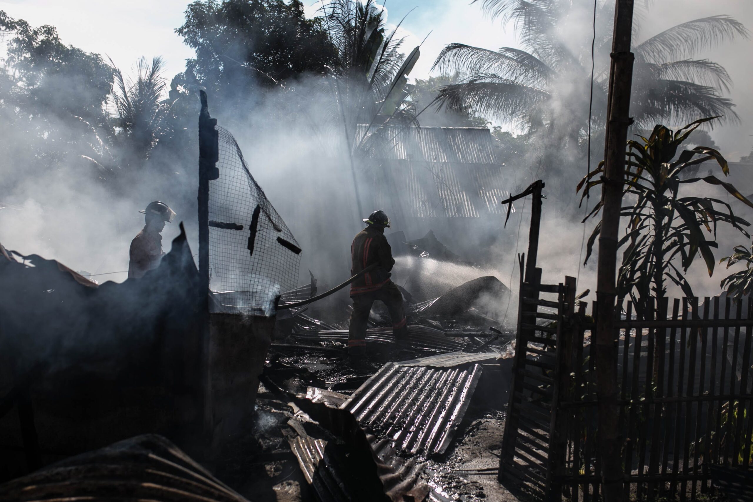 A firefighter battles a blaze at a business establishment, exemplifying the need to 'Prepare Your Business for Disaster' in an urban Australian setting